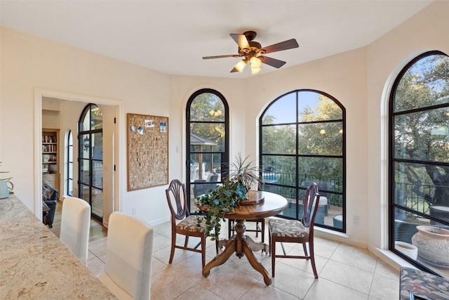 tiled dining space featuring a wealth of natural light and ceiling fan