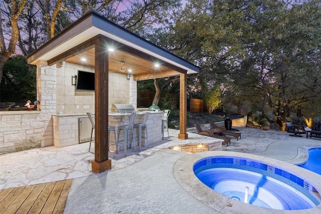 pool at dusk with grilling area, a patio, exterior bar, and an in ground hot tub