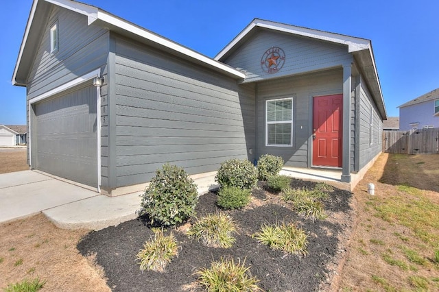 ranch-style house featuring a garage and fence