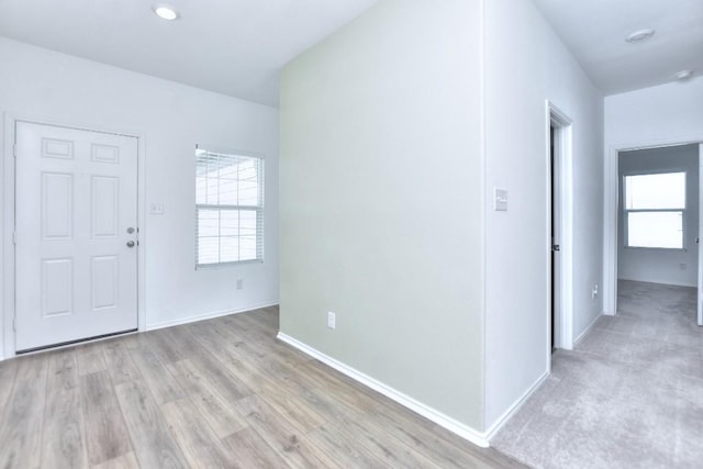 entrance foyer featuring a healthy amount of sunlight, light wood-style floors, and baseboards