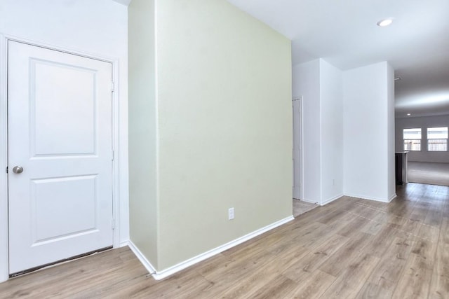 spare room featuring recessed lighting, light wood-type flooring, and baseboards