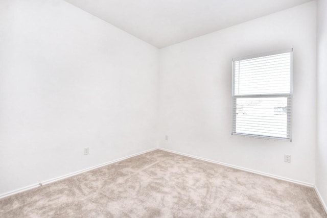 carpeted spare room featuring baseboards