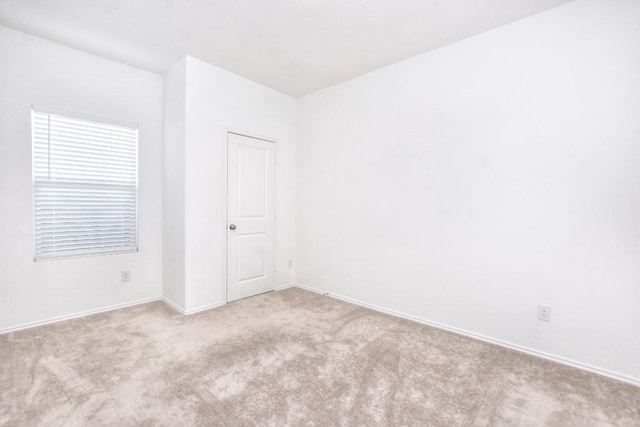 carpeted spare room with baseboards