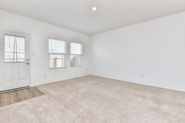 spare room featuring carpet, plenty of natural light, and baseboards