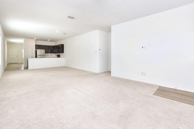 unfurnished living room featuring light carpet and visible vents