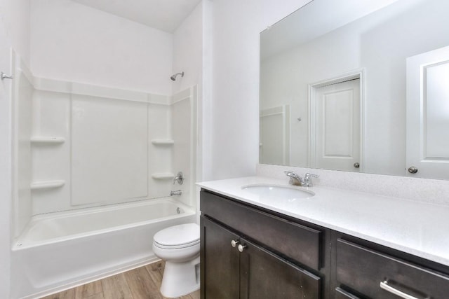 full bath with washtub / shower combination, vanity, wood finished floors, and toilet