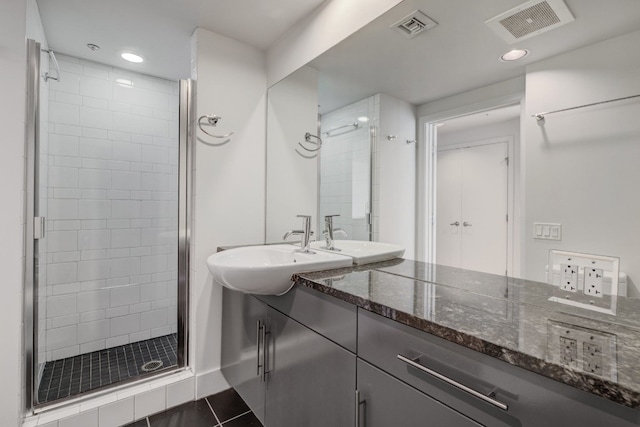 bathroom with tile patterned floors, vanity, and an enclosed shower