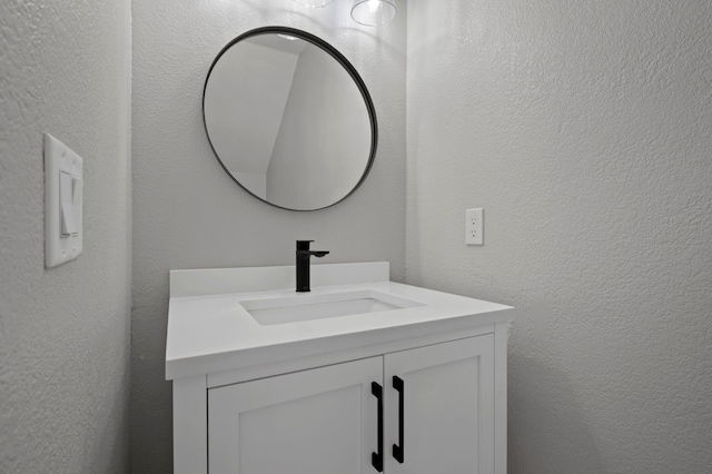 bathroom featuring vanity and a textured wall