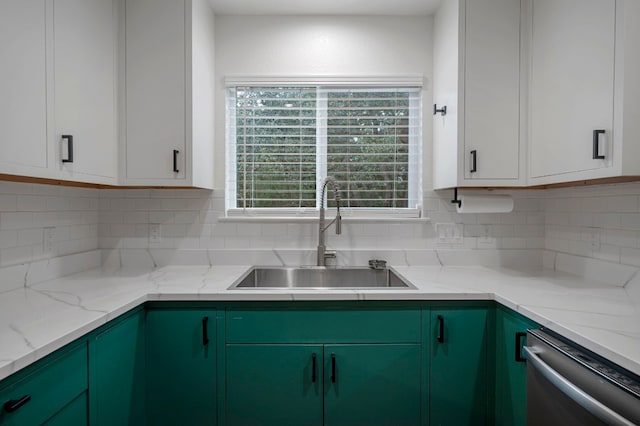 kitchen with decorative backsplash, light stone countertops, white cabinets, a sink, and dishwasher