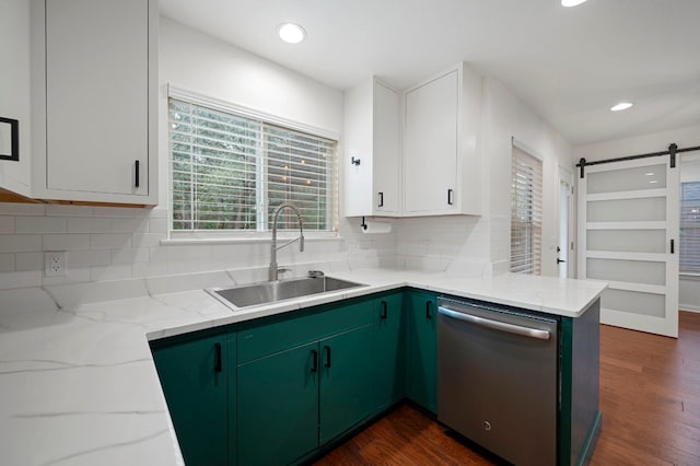 kitchen featuring a sink, stainless steel dishwasher, a barn door, and a wealth of natural light