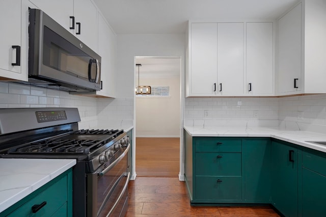 kitchen with white cabinets, stainless steel appliances, tasteful backsplash, and dark wood-type flooring