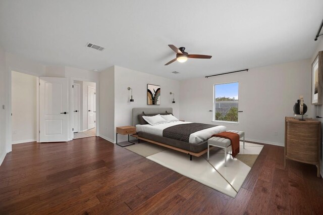 bedroom featuring visible vents, a ceiling fan, baseboards, and wood finished floors