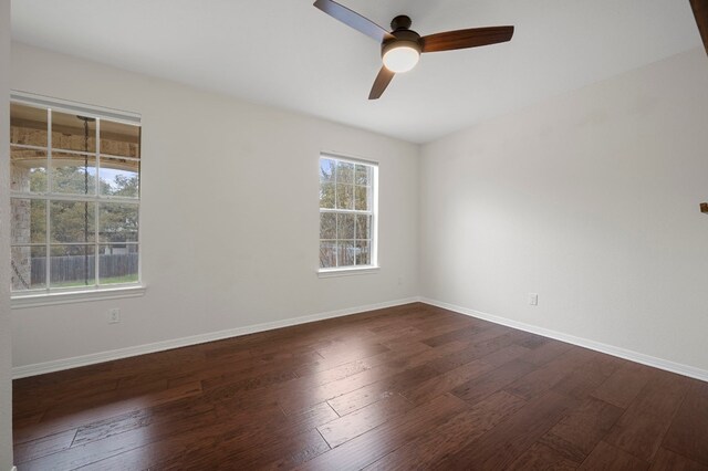 unfurnished room featuring baseboards, a ceiling fan, and dark wood-style floors