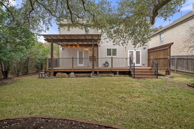 rear view of property featuring a lawn, a deck, a fenced backyard, and a pergola