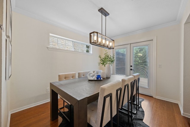 dining space with baseboards, ornamental molding, and wood finished floors