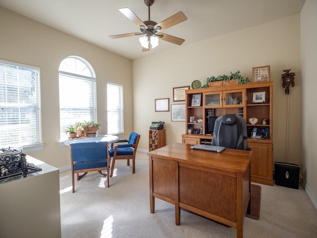 carpeted home office featuring ceiling fan