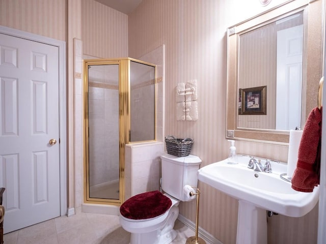 bathroom with sink, tile patterned floors, a shower with door, and toilet