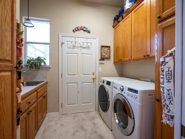 clothes washing area featuring independent washer and dryer, sink, light colored carpet, and cabinets