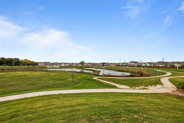 view of home's community featuring a water view and a yard