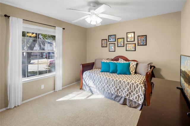 bedroom featuring multiple windows, light carpet, and ceiling fan