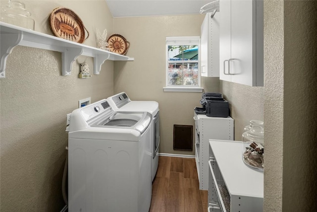 clothes washing area with washing machine and dryer and dark hardwood / wood-style floors