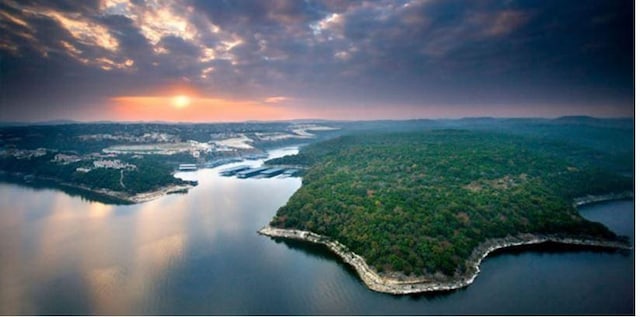 aerial view at dusk featuring a water view