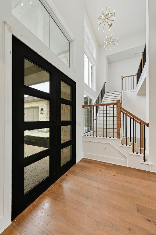 foyer featuring hardwood / wood-style flooring, a high ceiling, and a notable chandelier