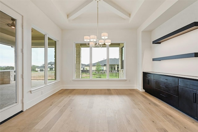 unfurnished dining area featuring coffered ceiling, plenty of natural light, beamed ceiling, and light wood-type flooring