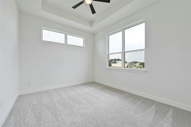 spare room featuring ceiling fan, a raised ceiling, and carpet floors