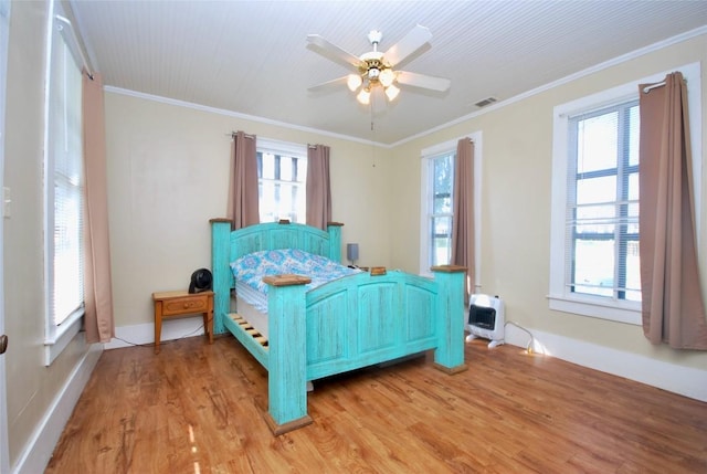 bedroom with hardwood / wood-style flooring, crown molding, and ceiling fan