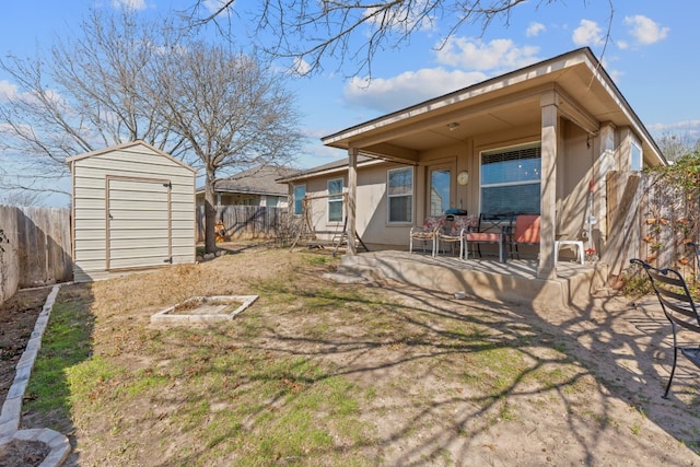 rear view of property with a storage unit, a yard, and a patio area