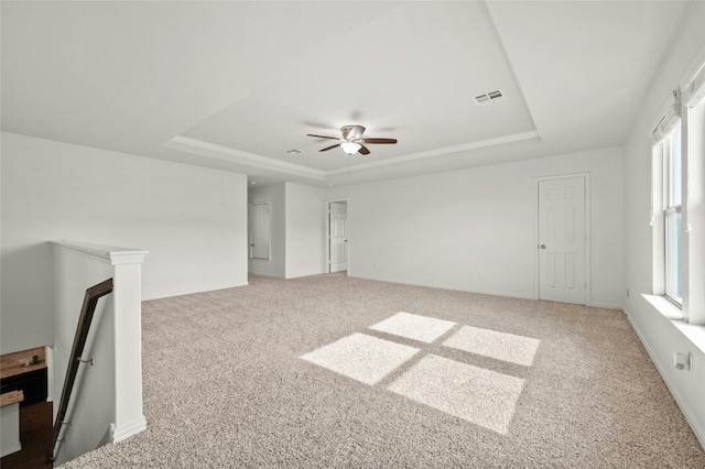 21005 Isle Of Glass St, Pflugerville, TX 78660 - empty room featuring a tray ceiling, carpet floors, plenty of natural light, and ceiling fan