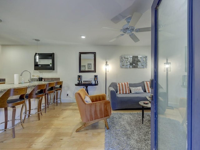 living room featuring ceiling fan and light hardwood / wood-style flooring