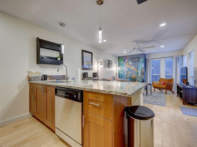 kitchen with sink, light stone counters, dishwasher, kitchen peninsula, and hanging light fixtures