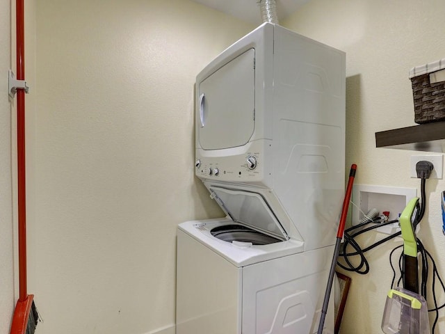 washroom with stacked washing maching and dryer