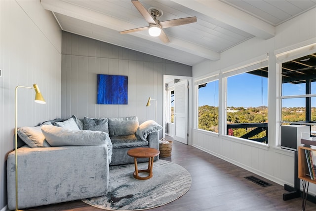 living room with dark wood-type flooring, ceiling fan, and vaulted ceiling with beams