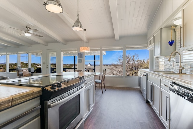 kitchen with pendant lighting, sink, appliances with stainless steel finishes, dark hardwood / wood-style floors, and tasteful backsplash