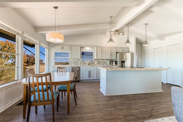 kitchen featuring a kitchen island, decorative light fixtures, sink, backsplash, and stainless steel appliances