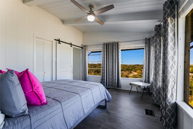 bedroom featuring a barn door, ceiling fan, dark hardwood / wood-style flooring, and vaulted ceiling with beams