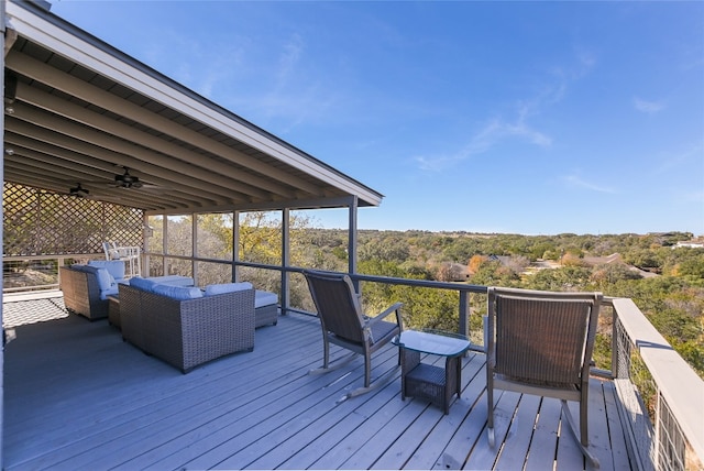 wooden deck featuring an outdoor living space and ceiling fan