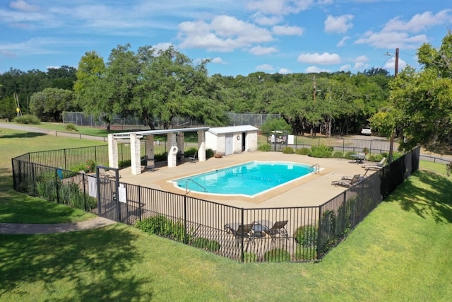 view of pool with a patio, an outdoor structure, and a lawn