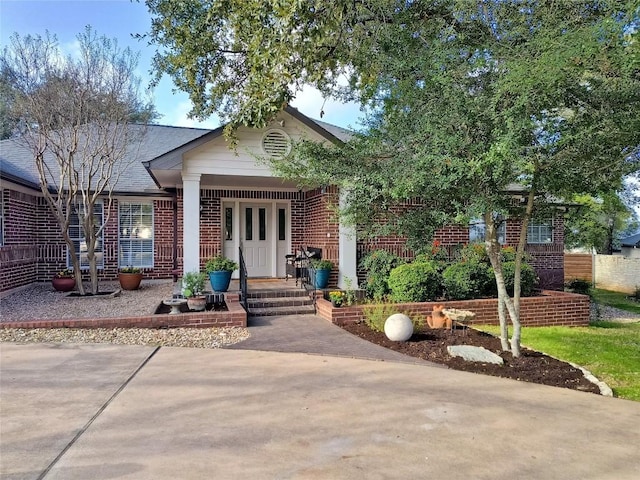 view of front of home featuring a porch and brick siding