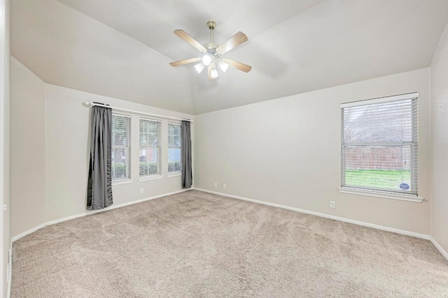 empty room featuring ceiling fan, light colored carpet, and vaulted ceiling