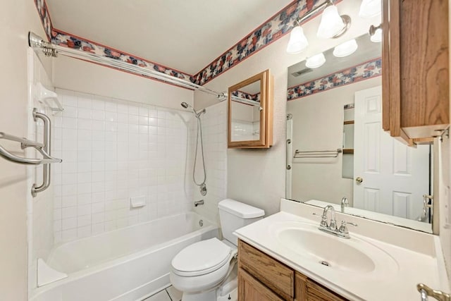 full bathroom featuring vanity, tiled shower / bath, and toilet