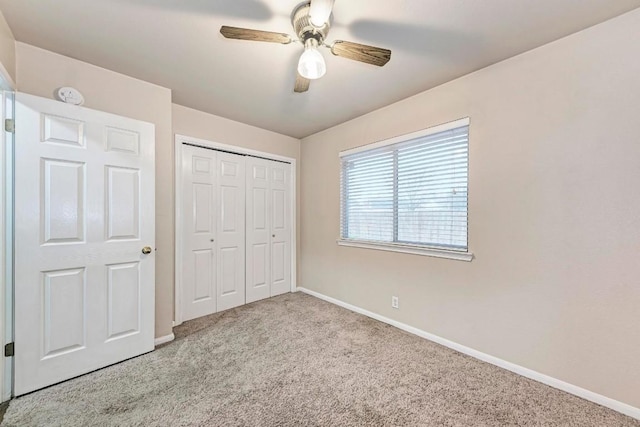 unfurnished bedroom with light colored carpet, ceiling fan, and a closet