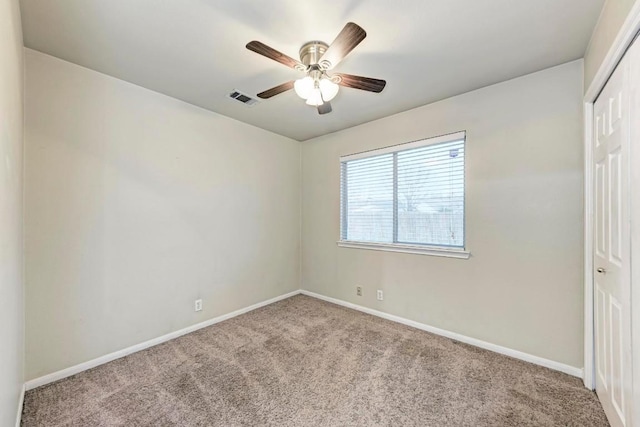 carpeted spare room featuring ceiling fan