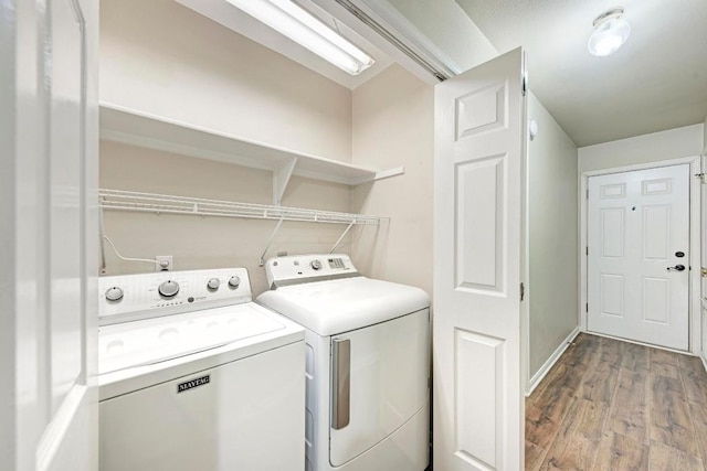 washroom with wood-type flooring and washer and clothes dryer