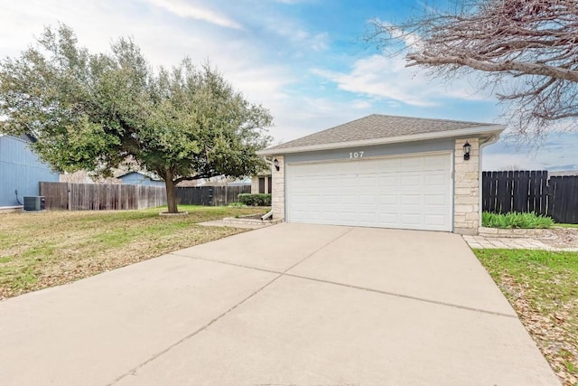 garage with central AC unit and a lawn