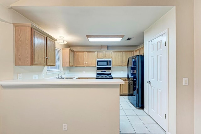 kitchen with light tile patterned flooring, light brown cabinetry, sink, kitchen peninsula, and stainless steel appliances