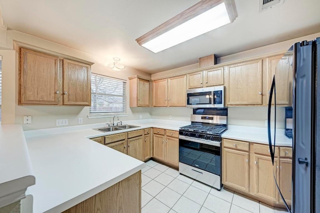 kitchen with stainless steel appliances, light brown cabinetry, sink, and light tile patterned floors